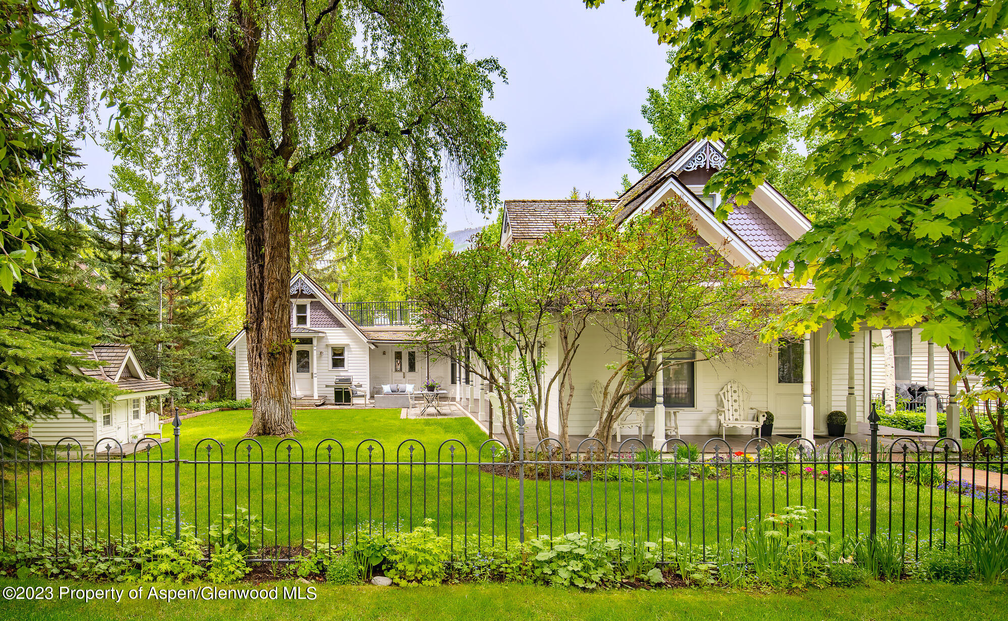 a front view of a house with a garden and trees