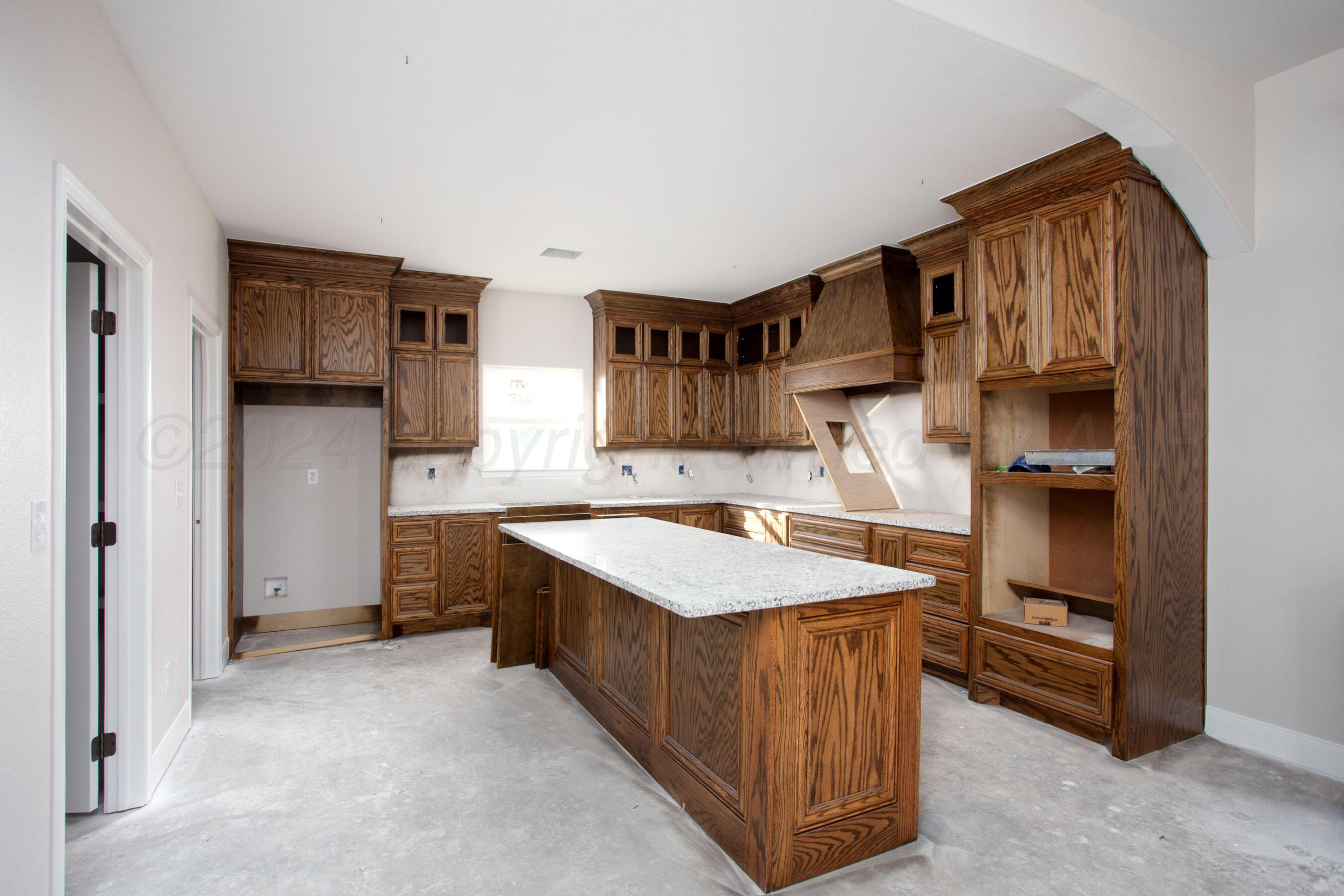 a kitchen that has a lot of cabinets in it and stainless steel appliances