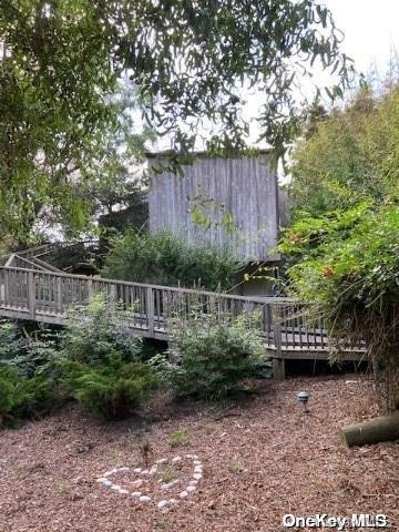 a view of garden with plants and wooden fence