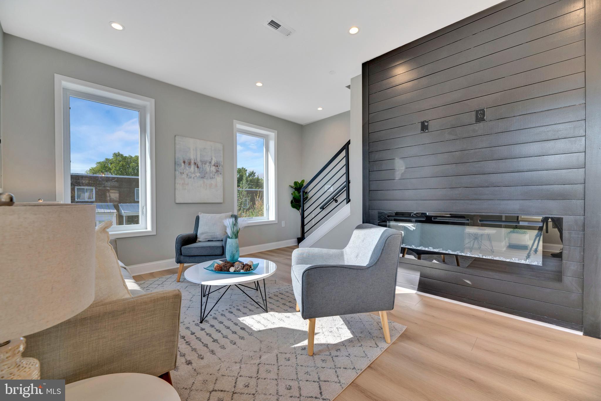 a living room with couches chairs and a potted plant