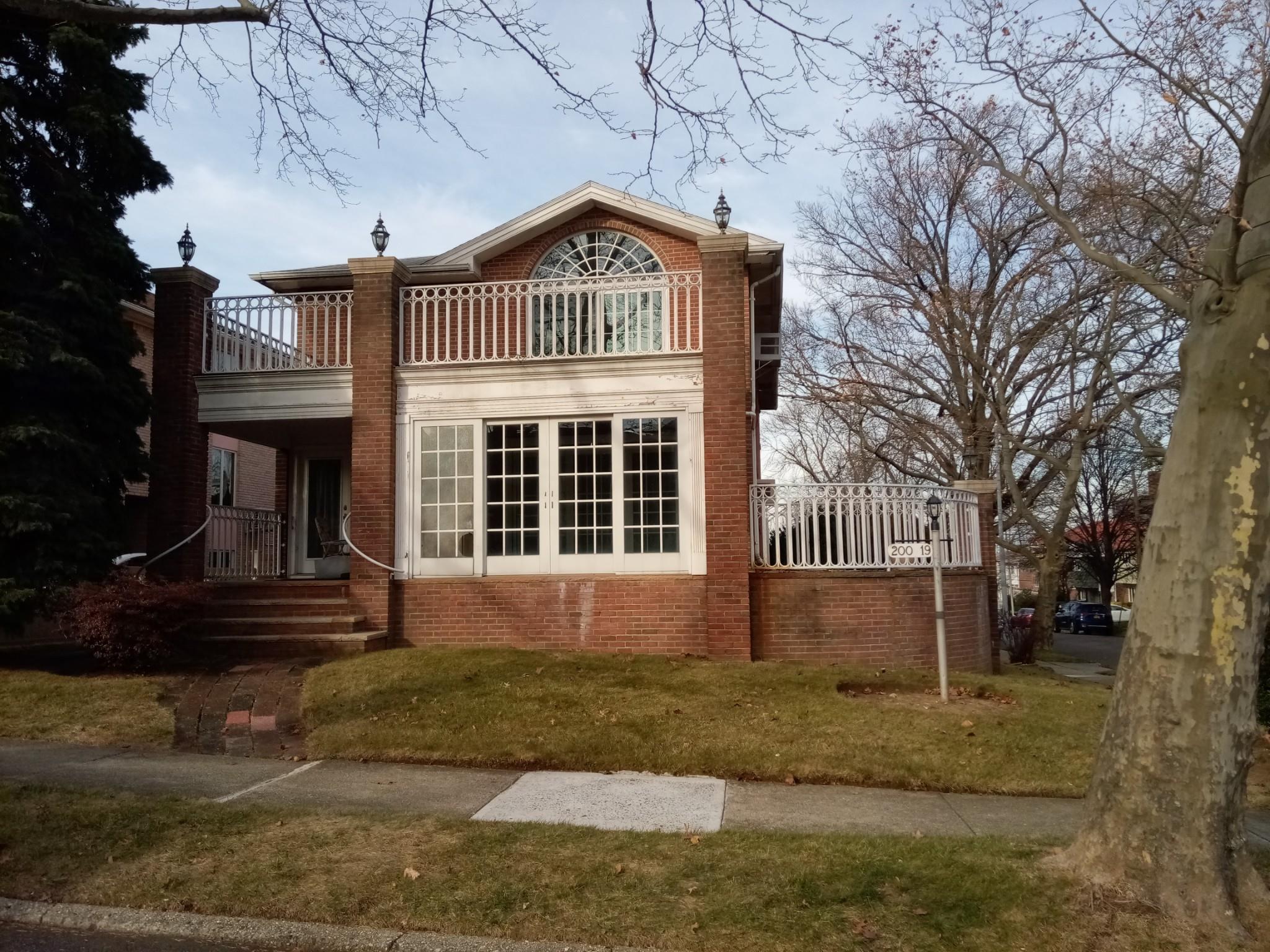 Rear view of house featuring a lawn and a balcony