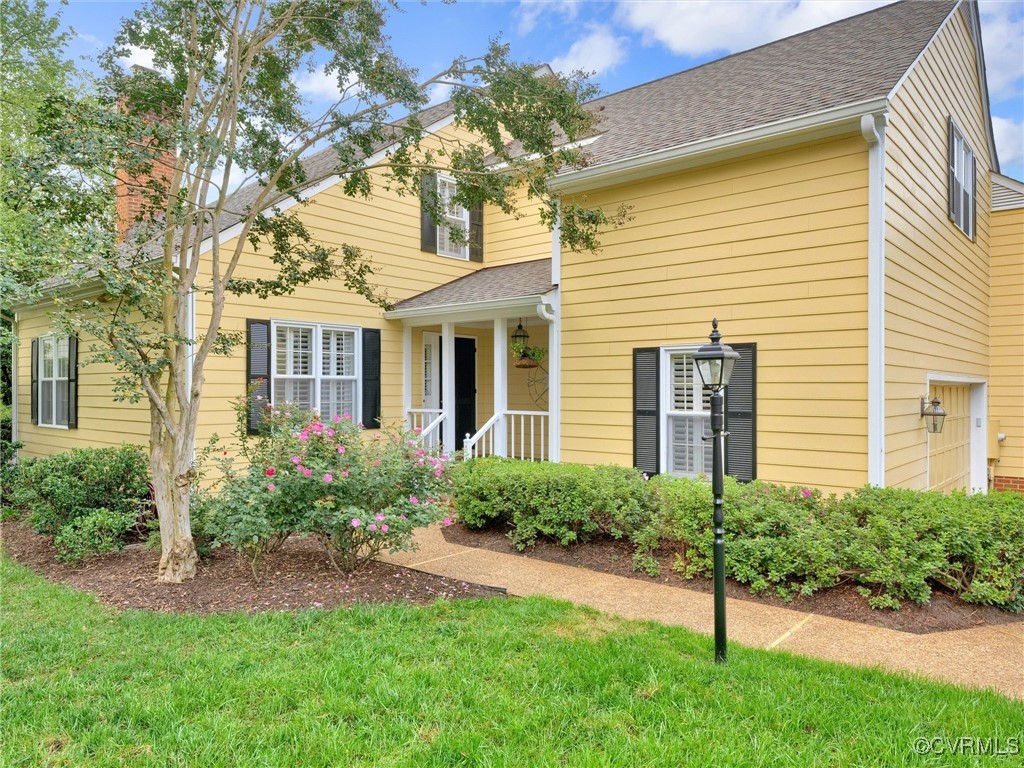 a front view of a house with a yard and trees