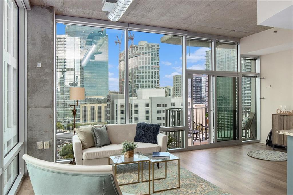 a living room with furniture and a large window with wooden floor