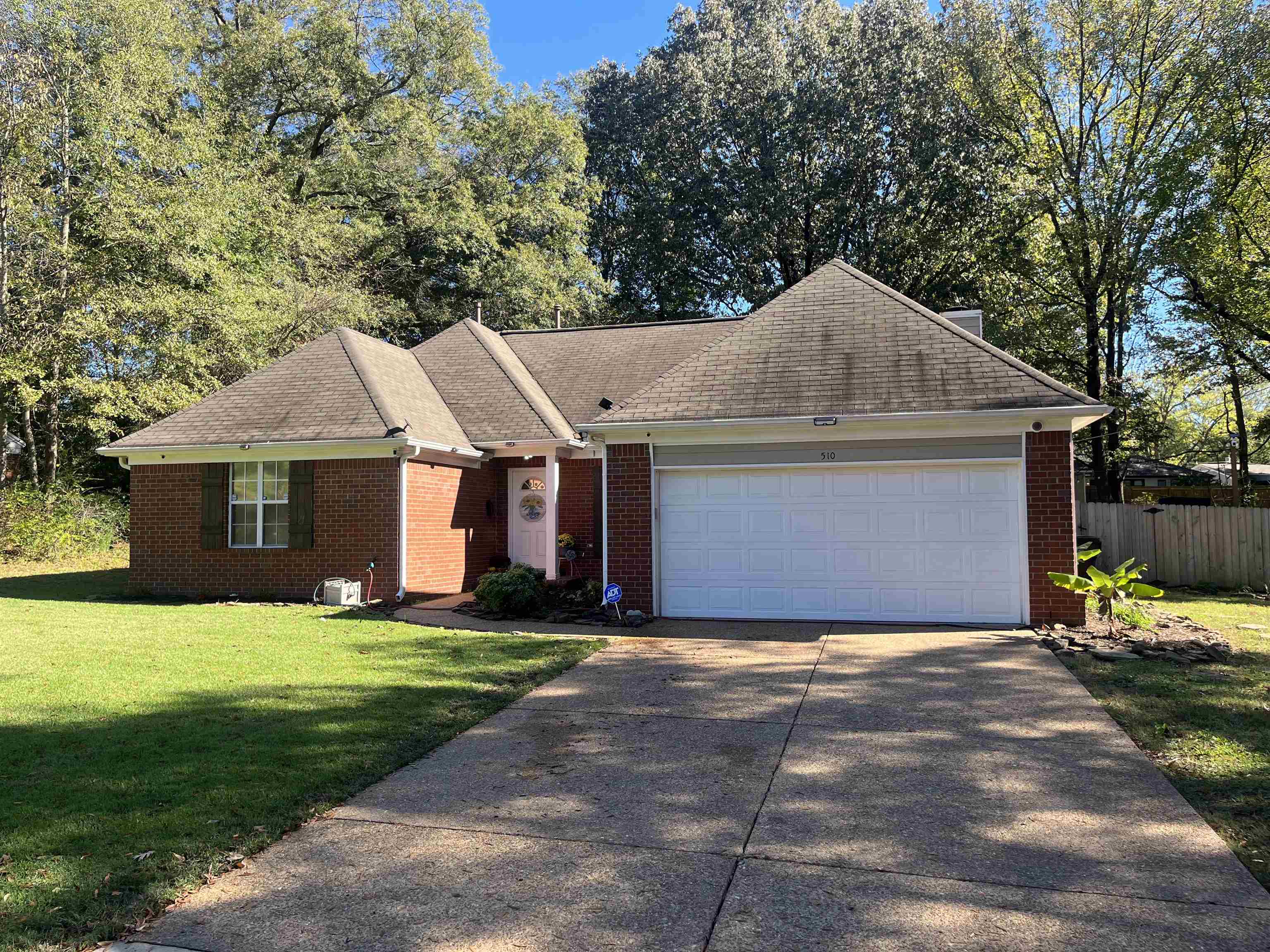 Ranch-style home featuring a garage and a front lawn