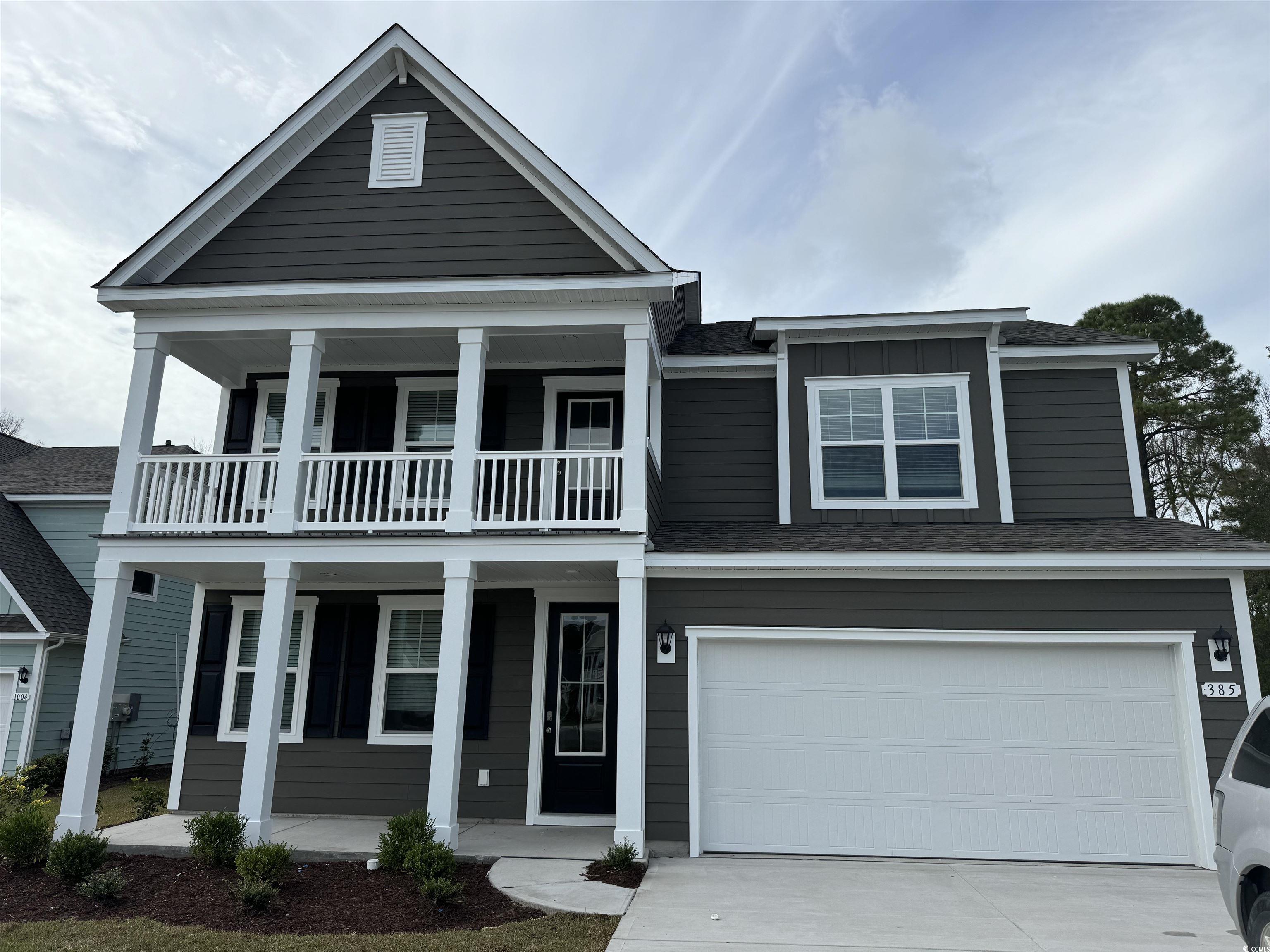 View of front of home featuring a balcony, covered