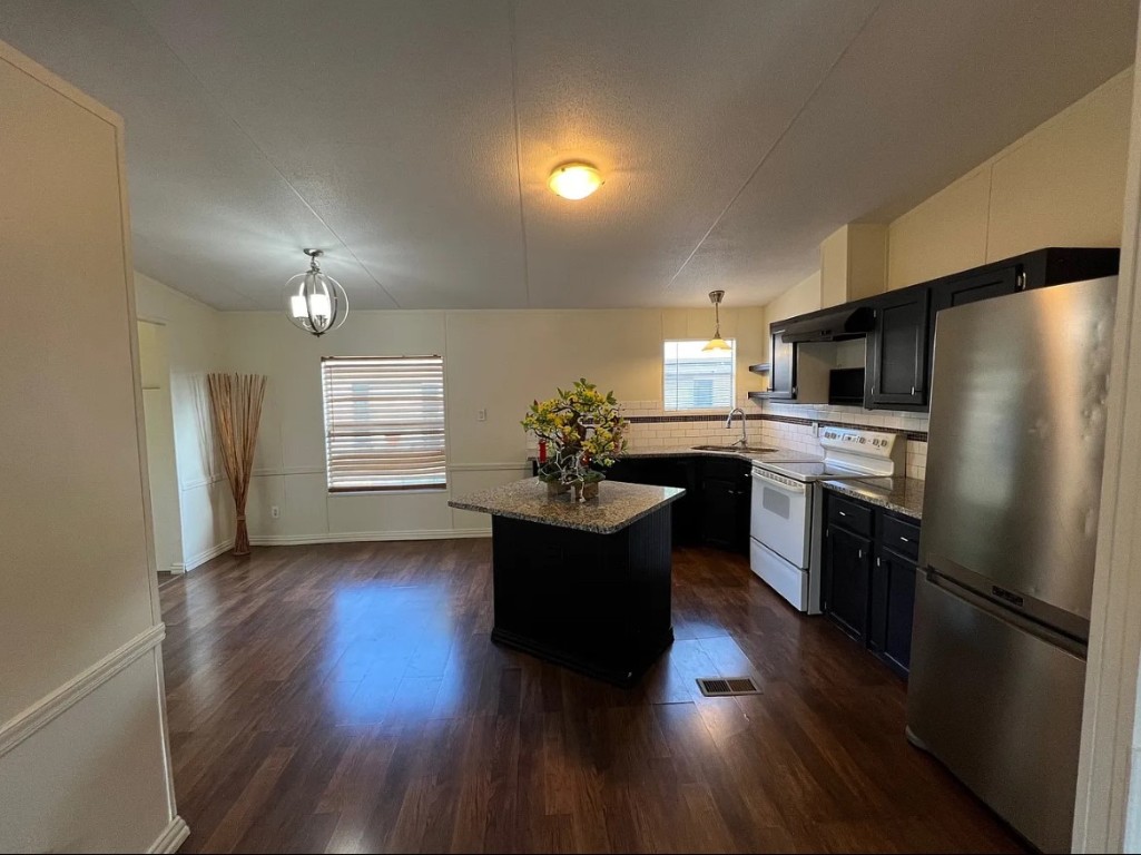 a kitchen with a refrigerator and a stove top oven