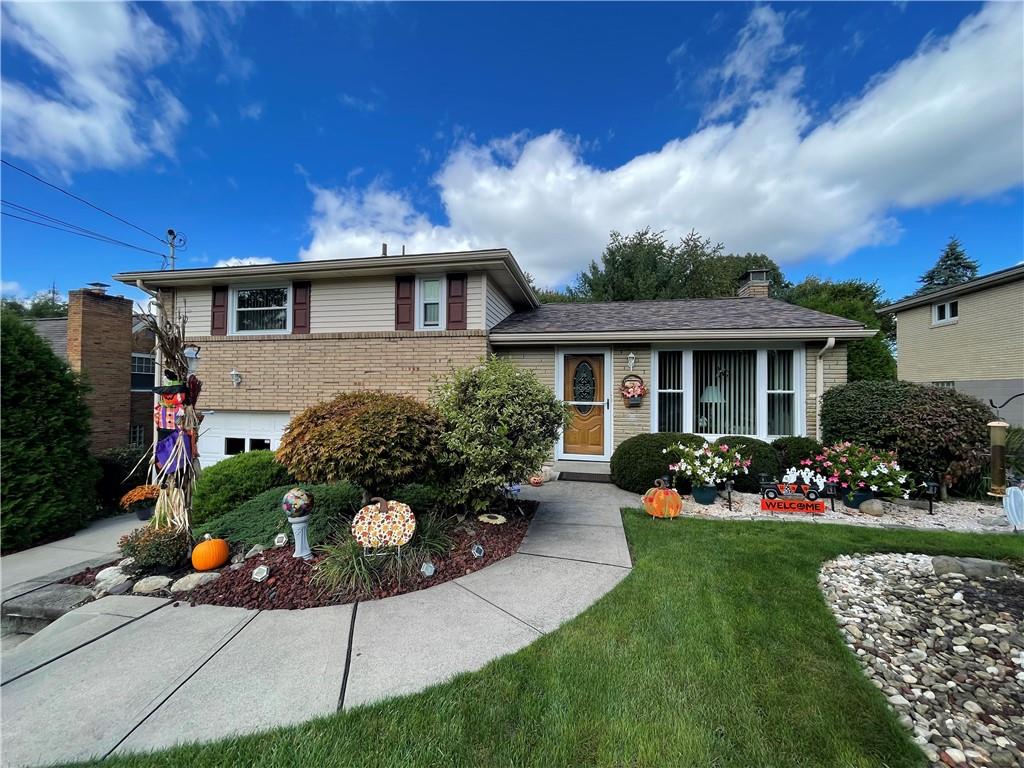 a front view of a house with a yard and potted plants