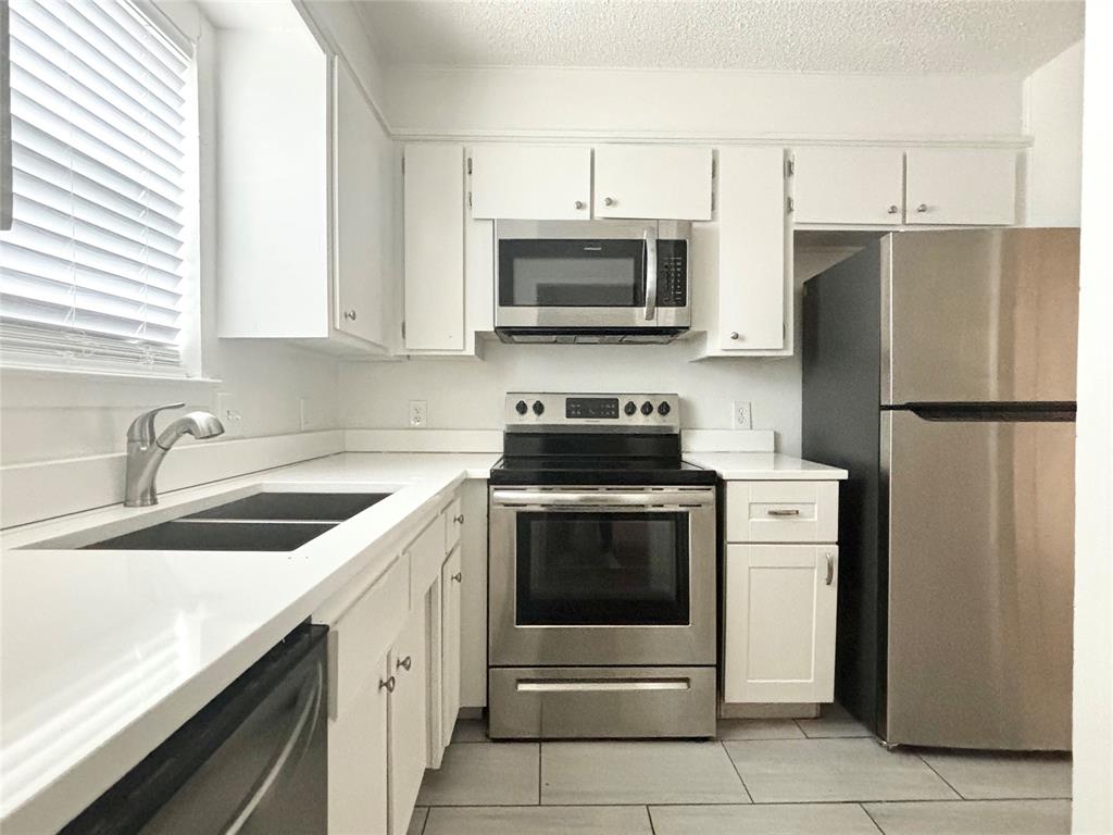 a kitchen with a sink stove and refrigerator