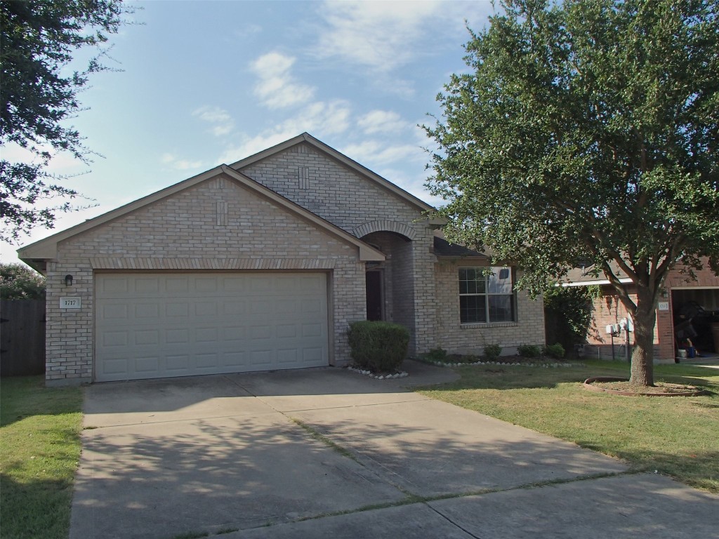 a front view of house with yard and trees around