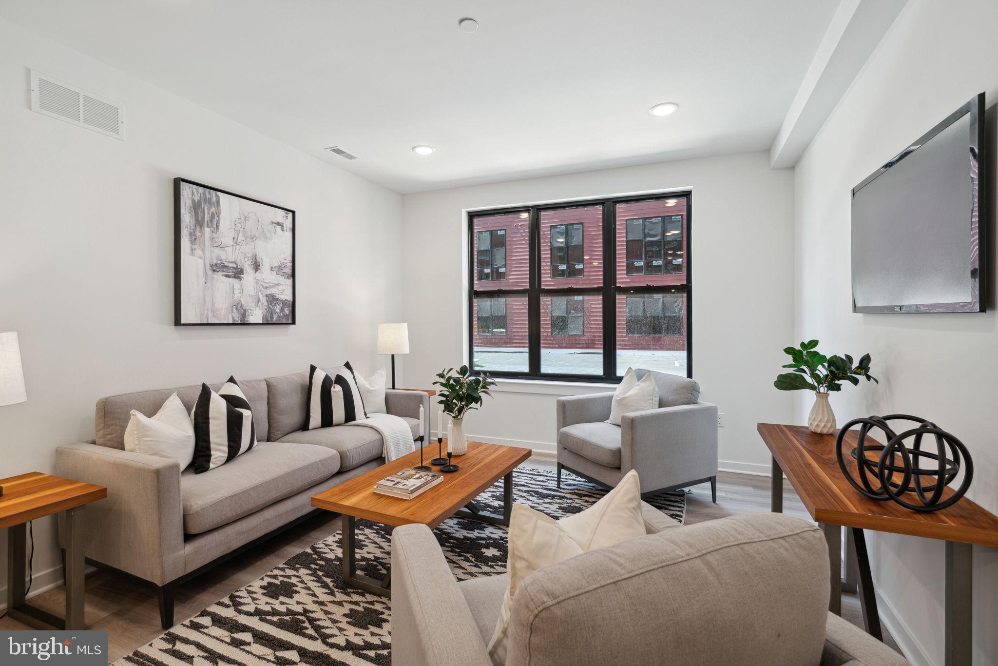 a living room with furniture potted plant and a large window