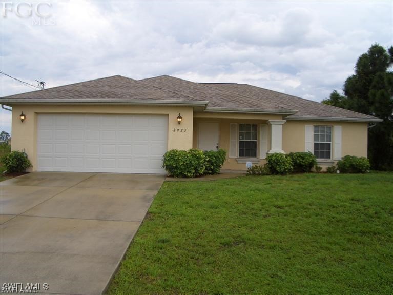 a front view of a house with a yard and garage