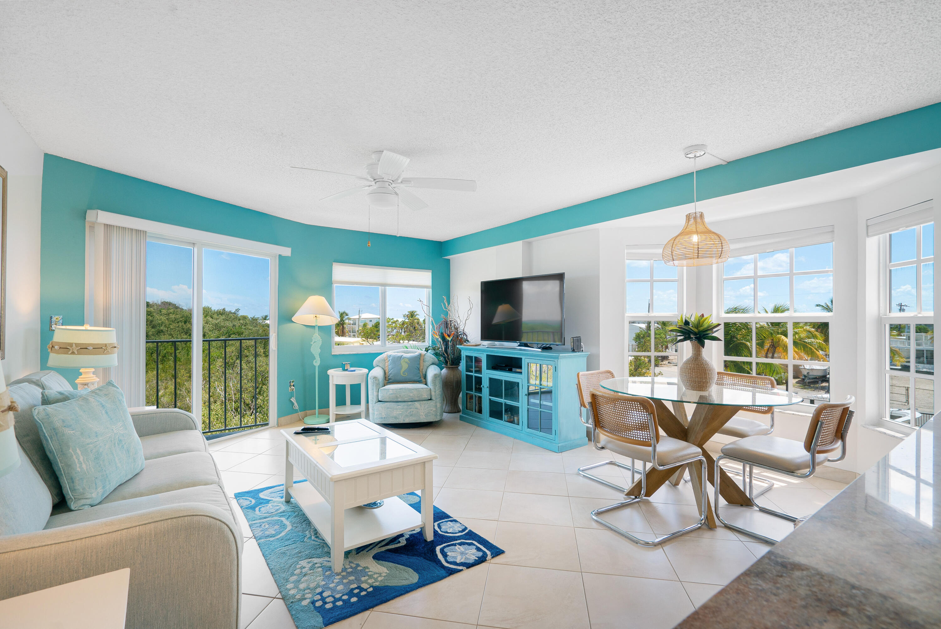 a living room with furniture a large window and a flat screen tv