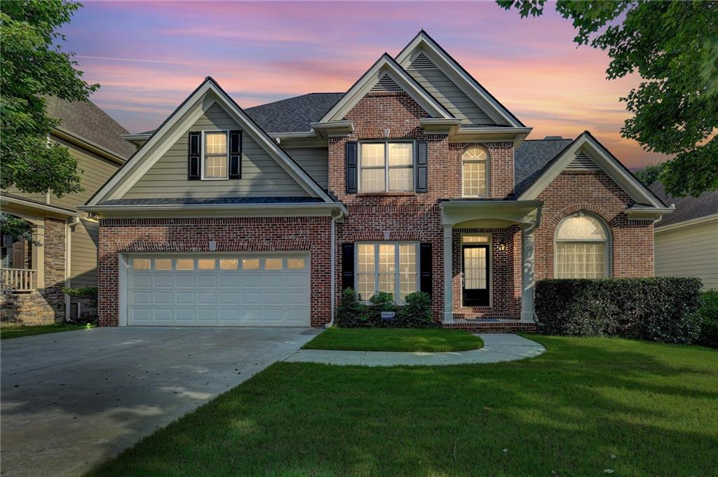 a front view of a house with a yard and garage