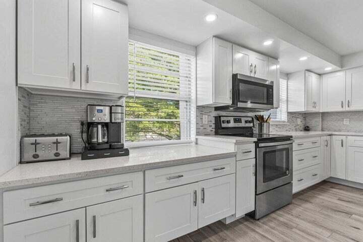 a kitchen with cabinets stainless steel appliances and a window