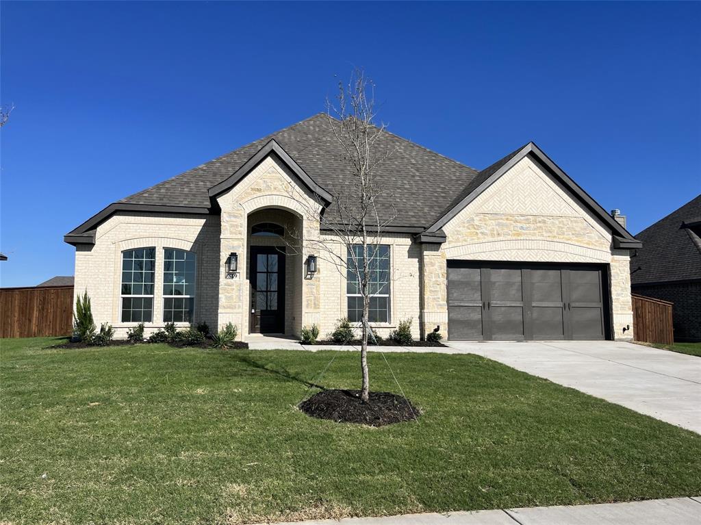 a front view of a house with a yard and garage