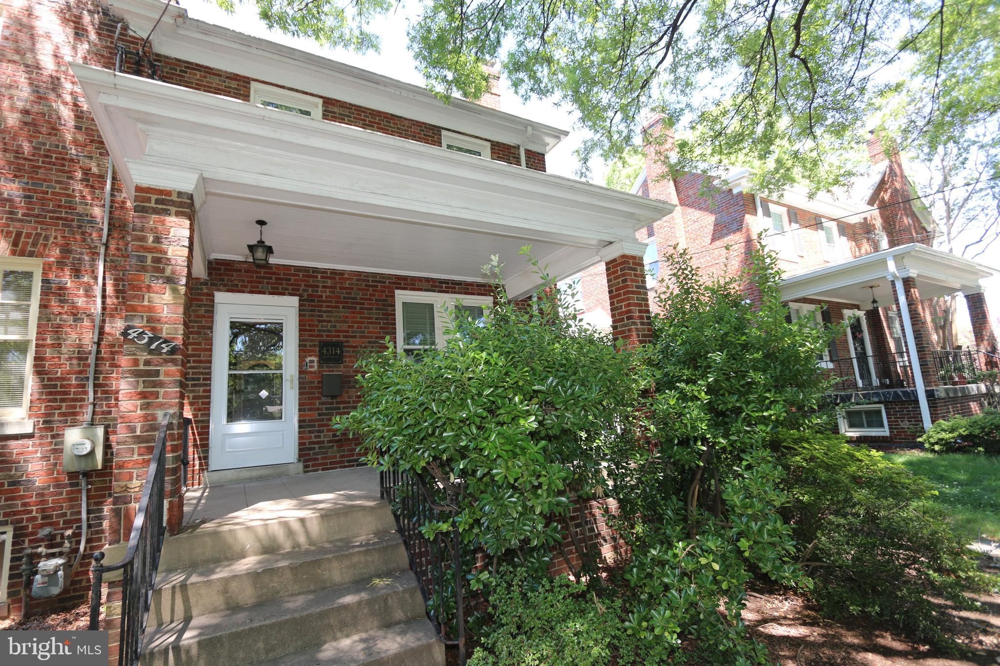 a view of a house with brick walls and a tree