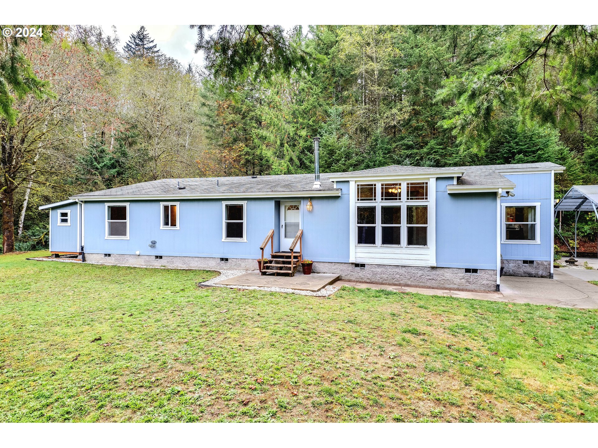 a view of a house with a yard and sitting area