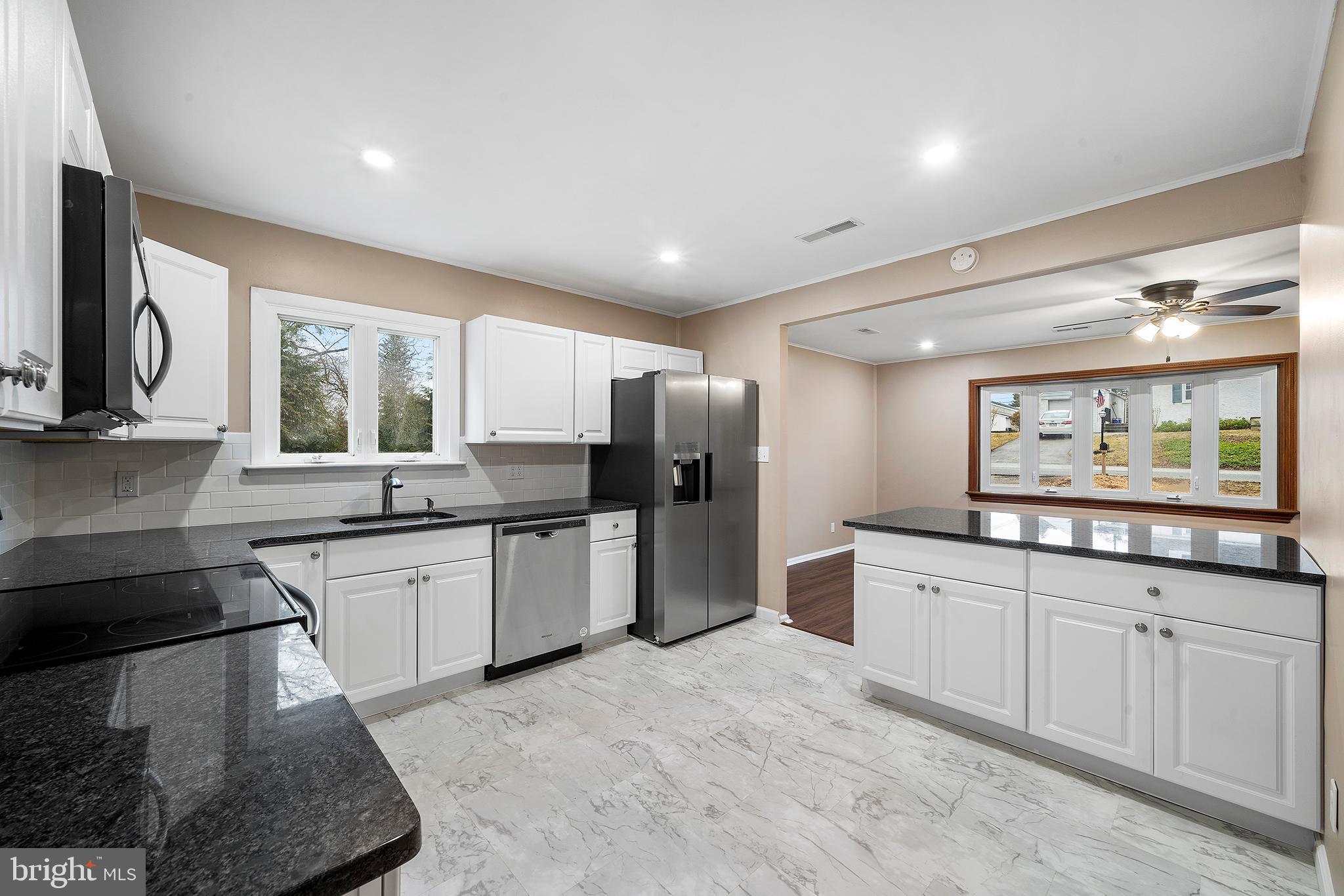 a kitchen with stainless steel appliances granite countertop a stove a sink and a refrigerator