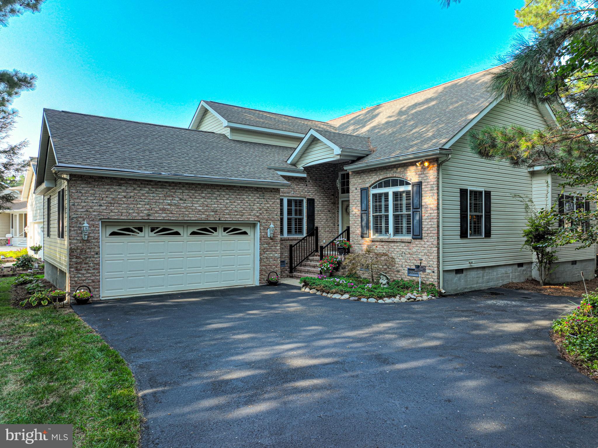 a front view of a house with a garden and trees