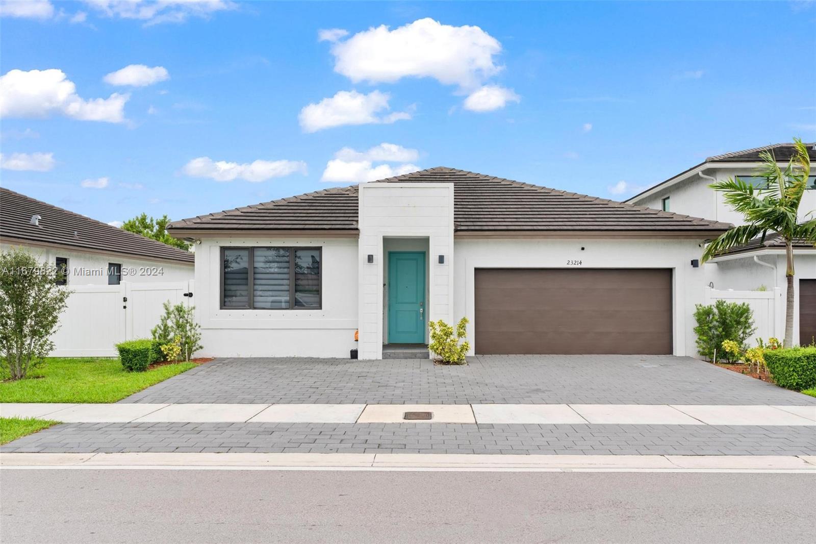 a front view of a house with a yard and a garage