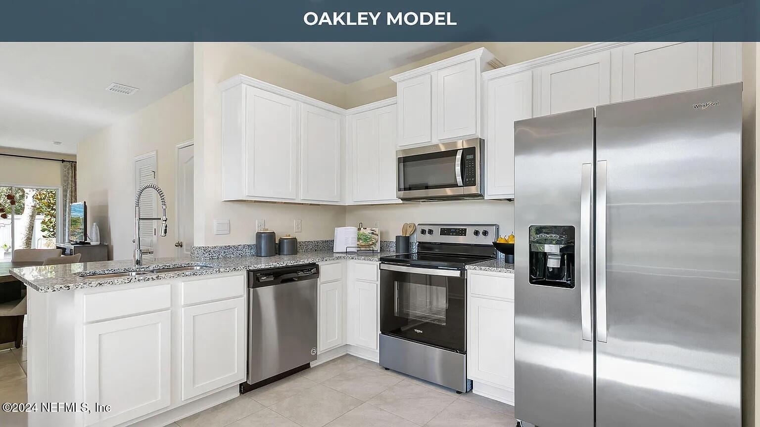 a kitchen with a sink stainless steel appliances and white cabinets