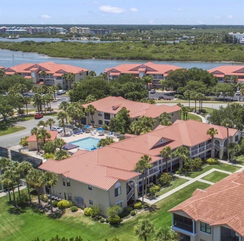 an aerial view of residential houses with outdoor space and lake view