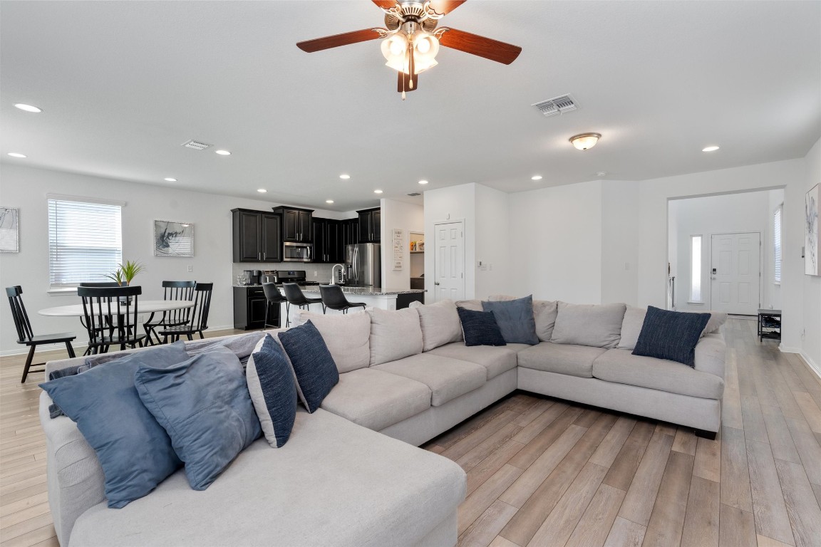 a living room with furniture kitchen view and a chandelier