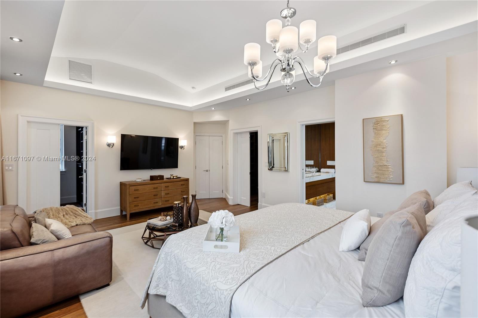 a living room with furniture a flat screen tv and a chandelier