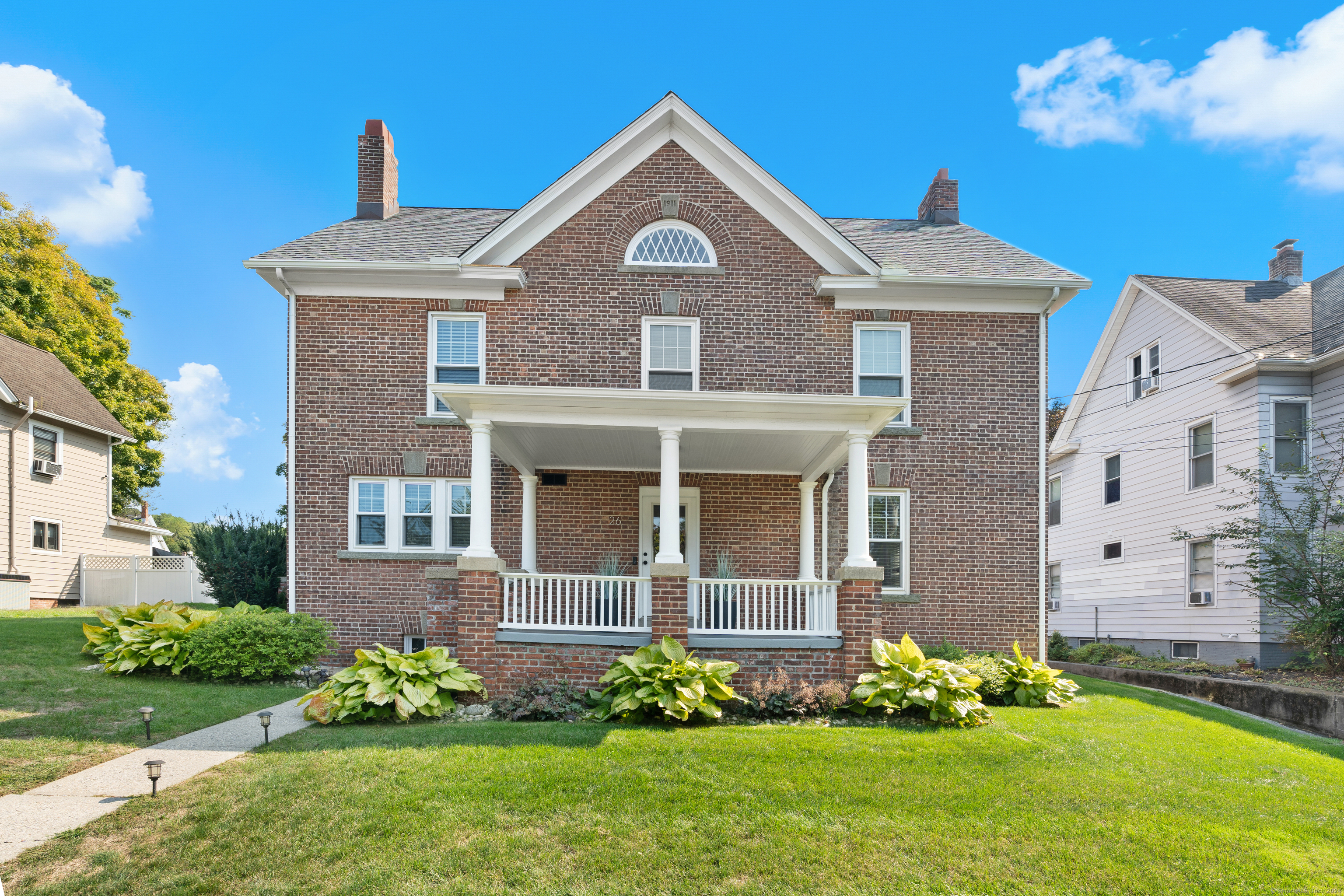 a front view of a house with a garden