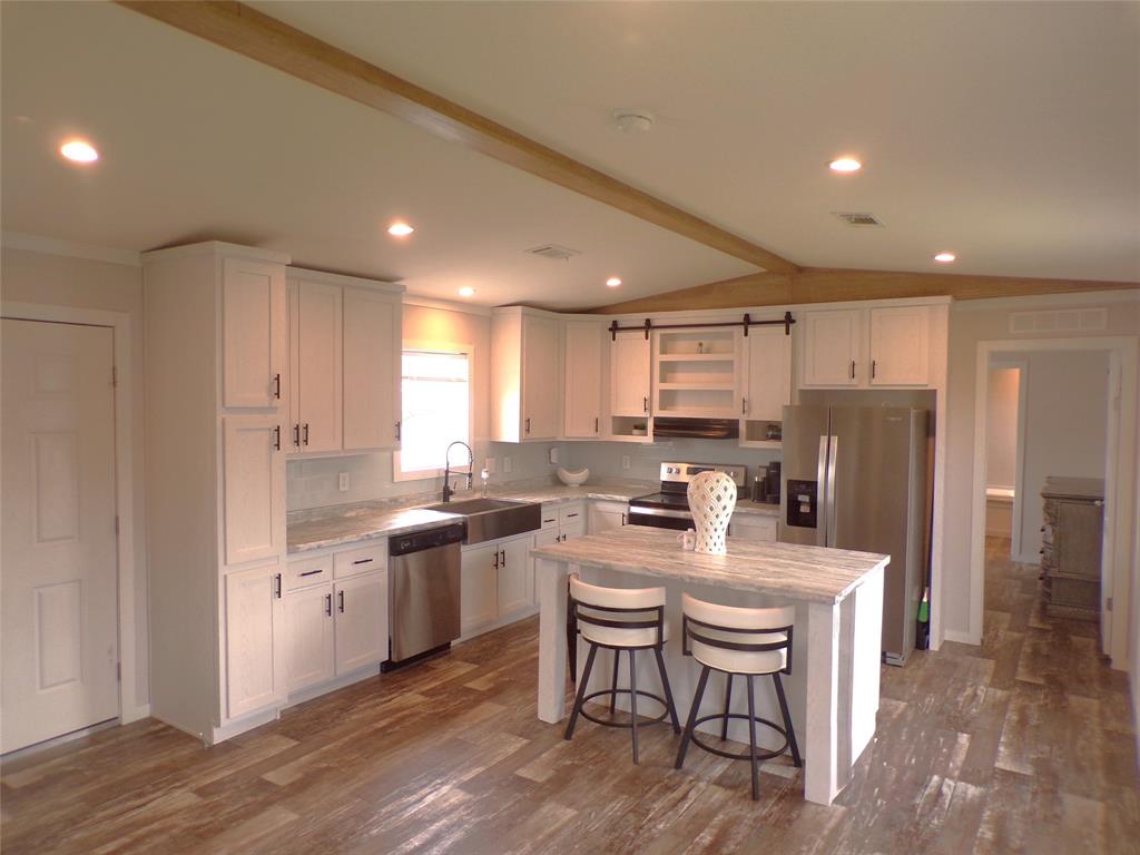 a large kitchen with kitchen island a sink table and chairs