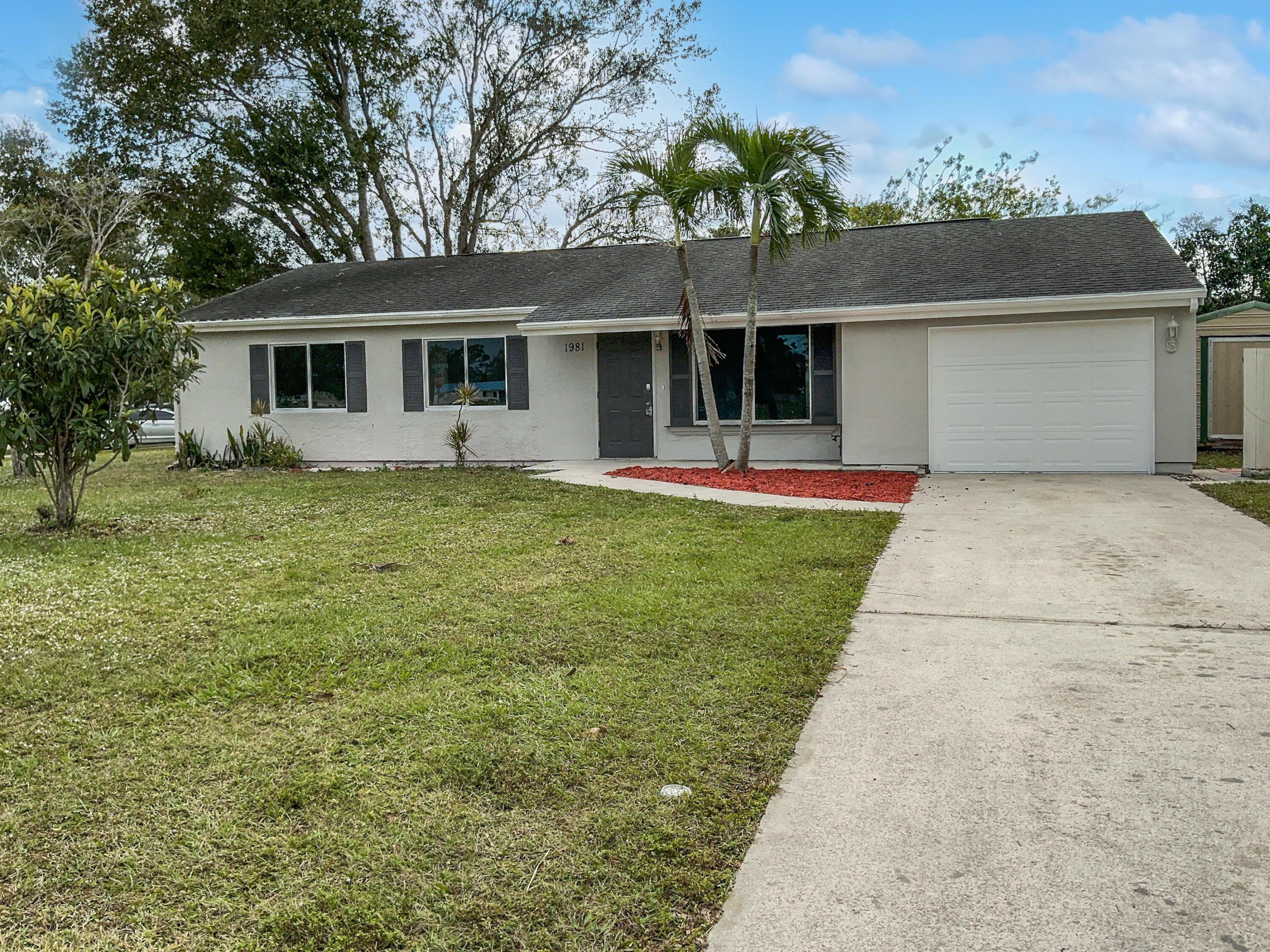 a front view of a house with a garden and yard