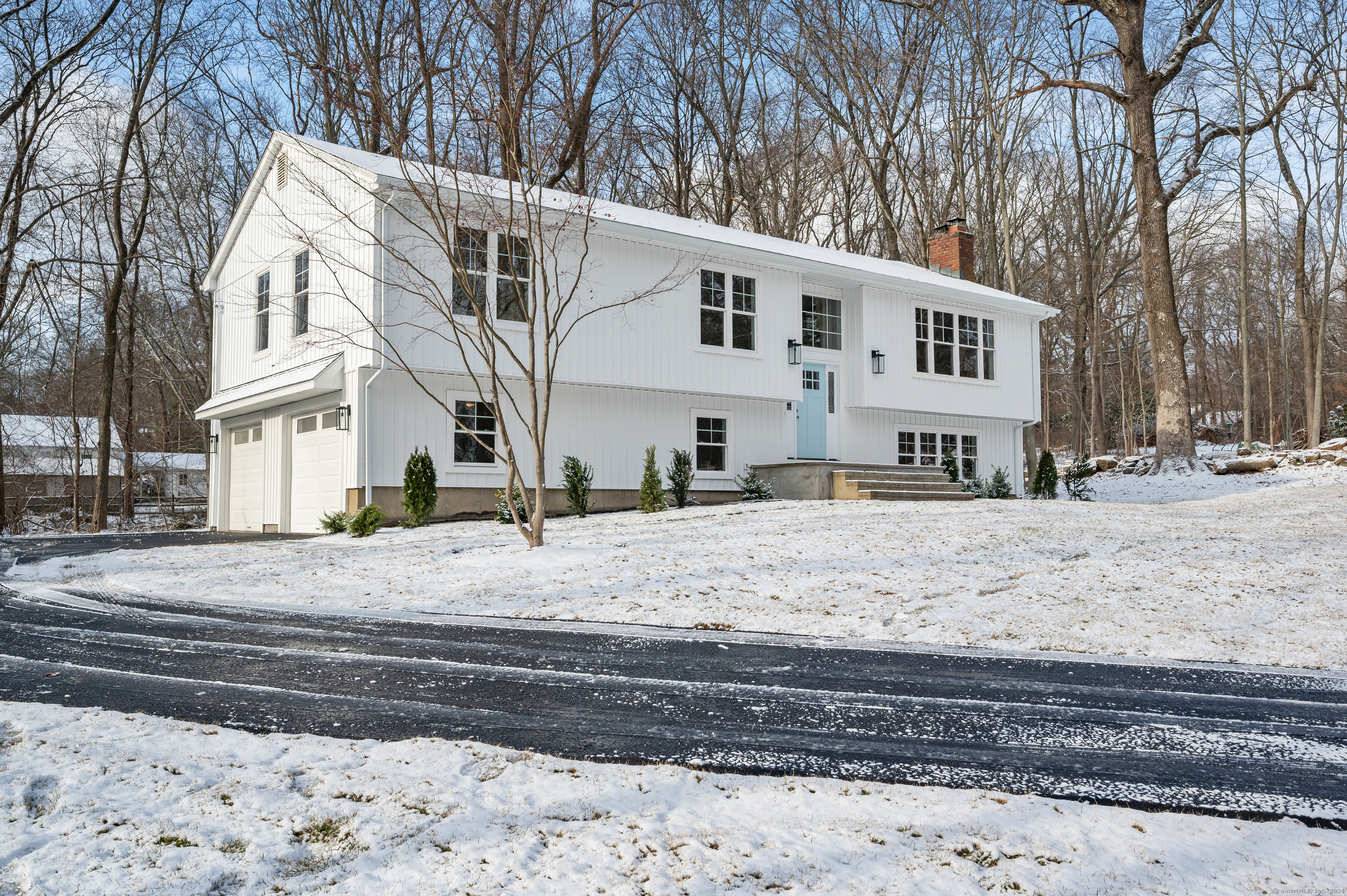 a view of a white house with a snow on the road