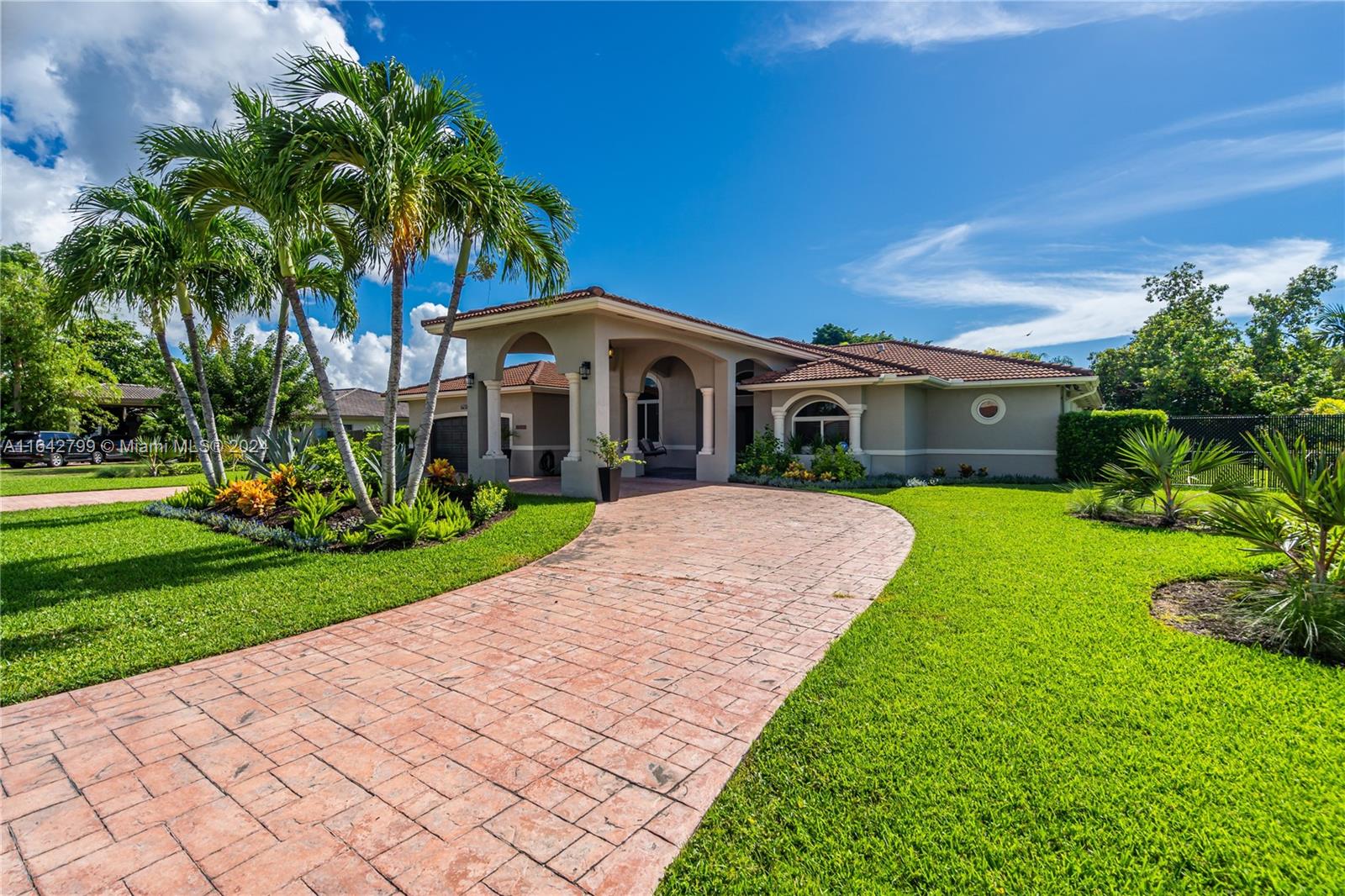 a front view of a house with a yard and potted plants