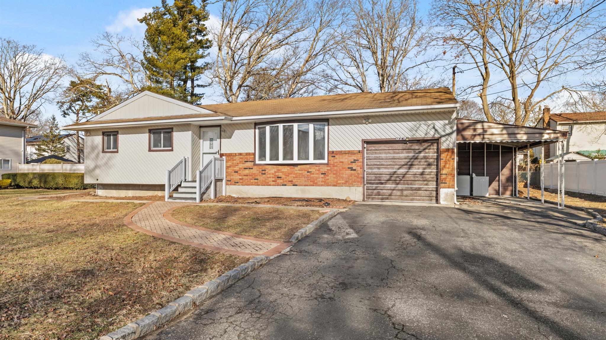 Single story home with a sunroom, a garage, and a front lawn