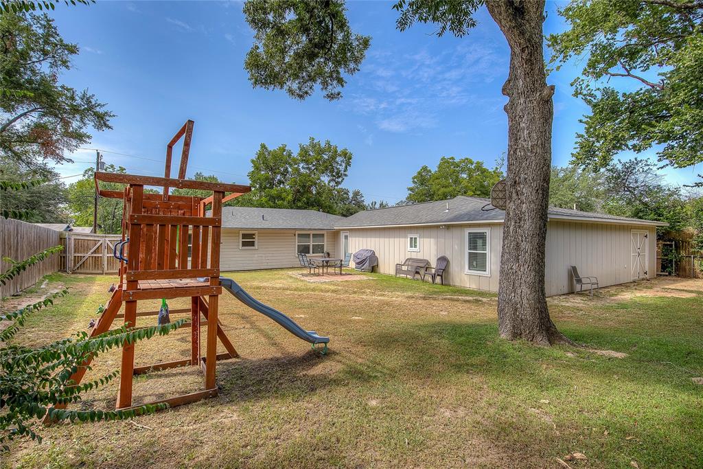 a view of a house with backyard and a tree