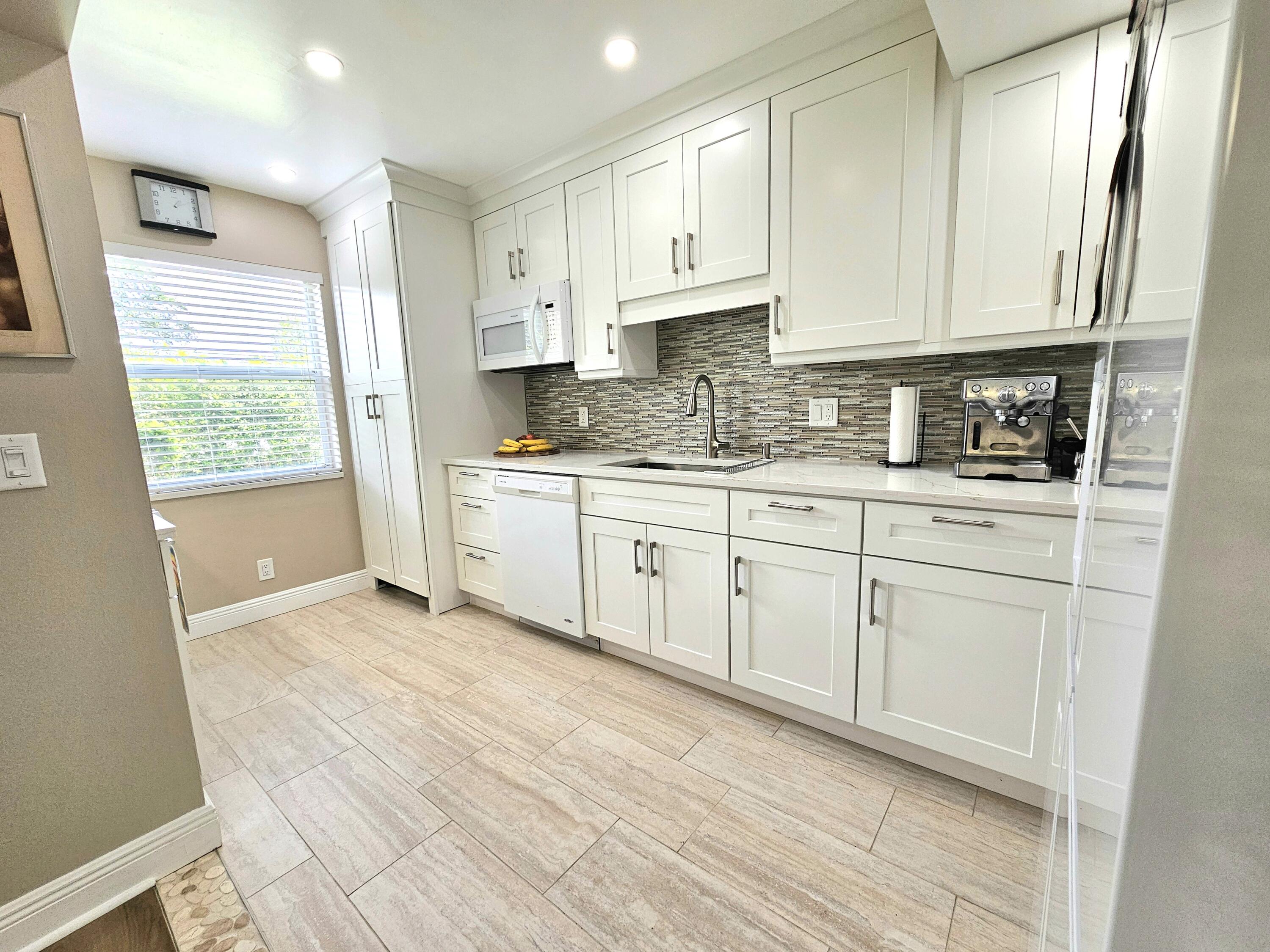 a kitchen with stainless steel appliances granite countertop a sink a stove a refrigerator and cabinets