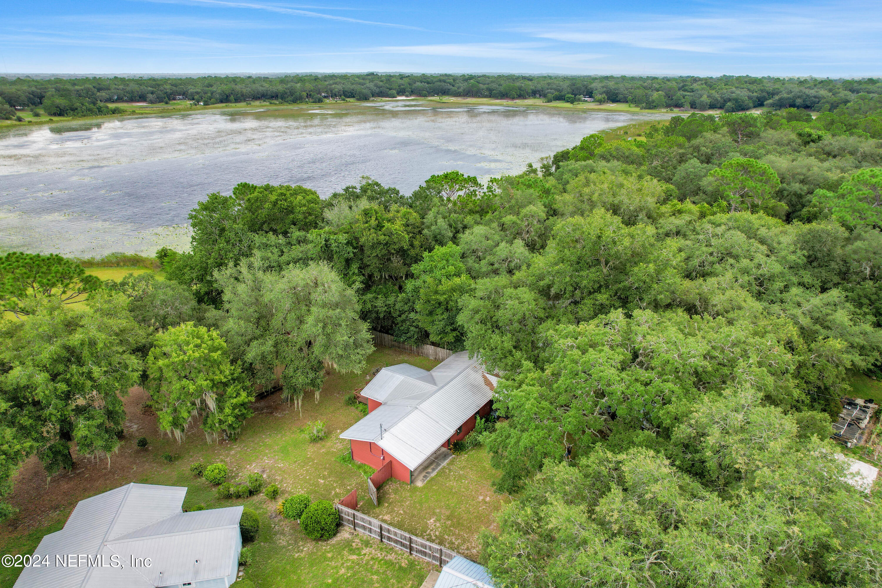 an aerial view of a house with a yard and lake view