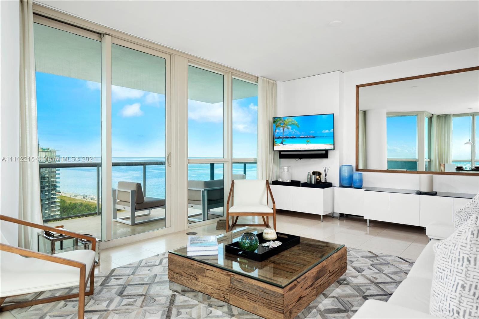 a living room with furniture flat screen tv and a large window