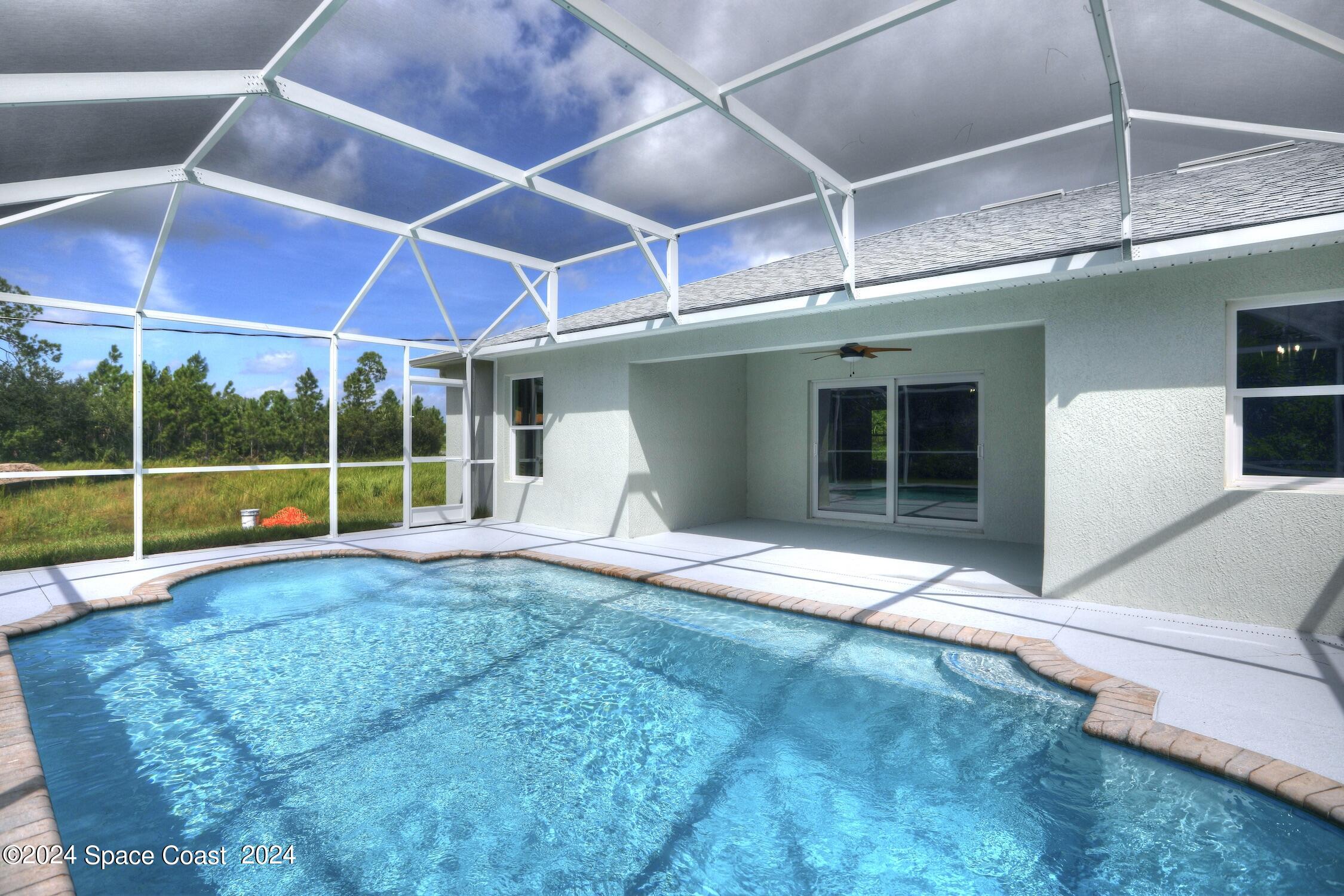 a view of an empty room with a floor to ceiling window and yard