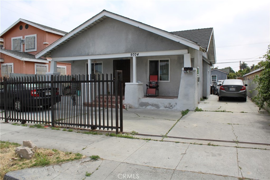 a view of a house with a small yard and wooden fence