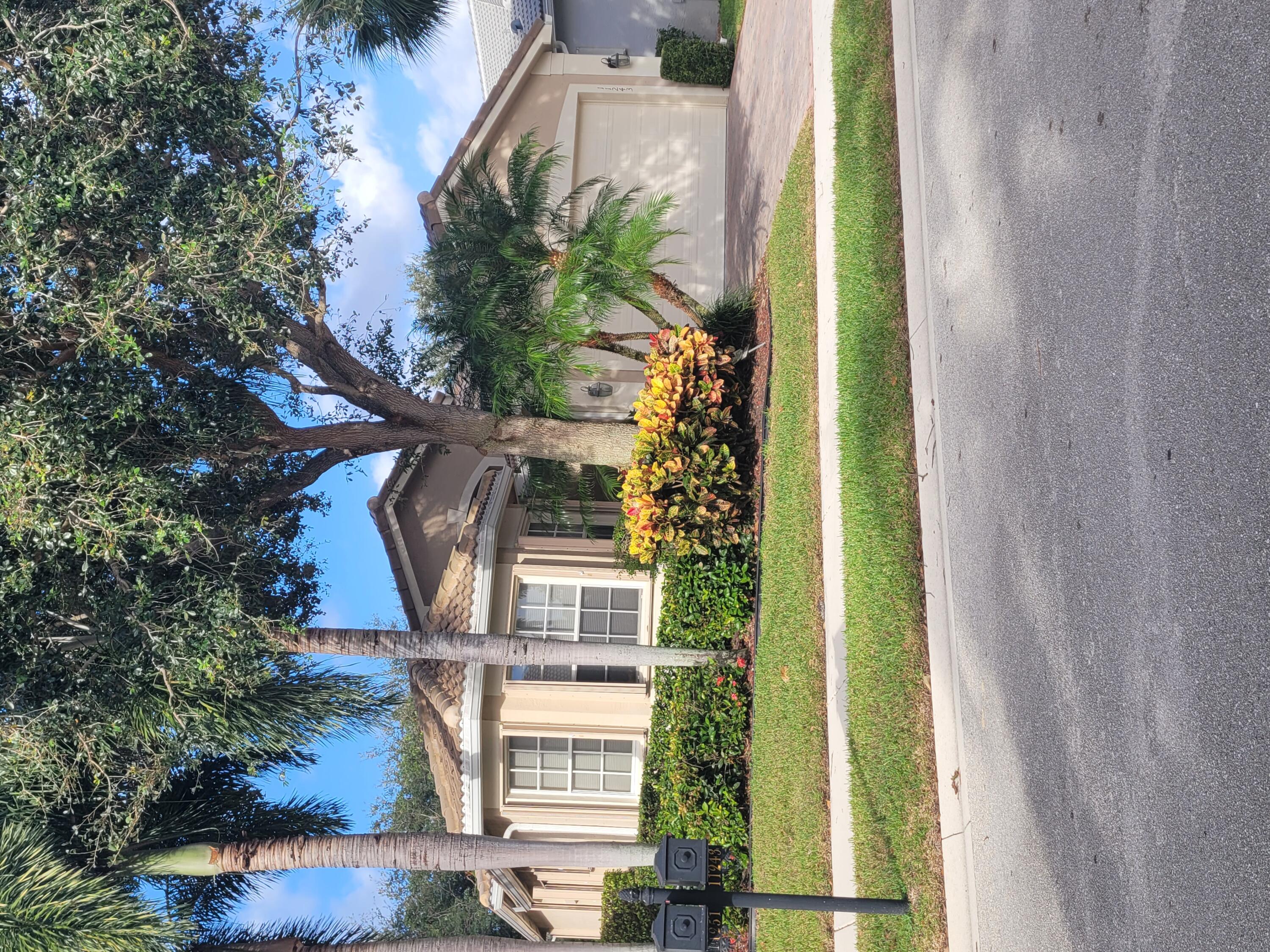 a front view of a house with a garden and trees