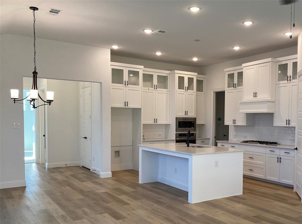 a kitchen with stainless steel appliances kitchen island granite countertop a refrigerator and a stove top oven