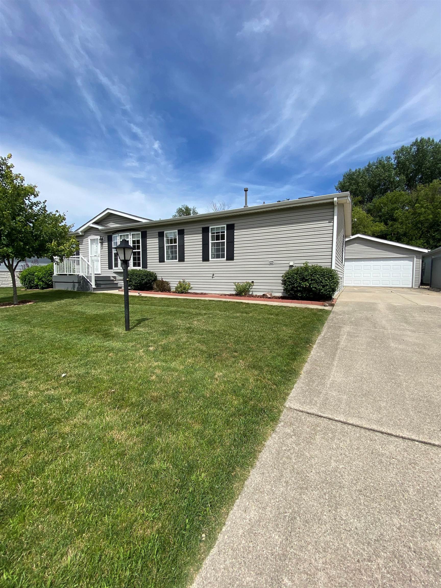 a front view of a house with a yard and trees