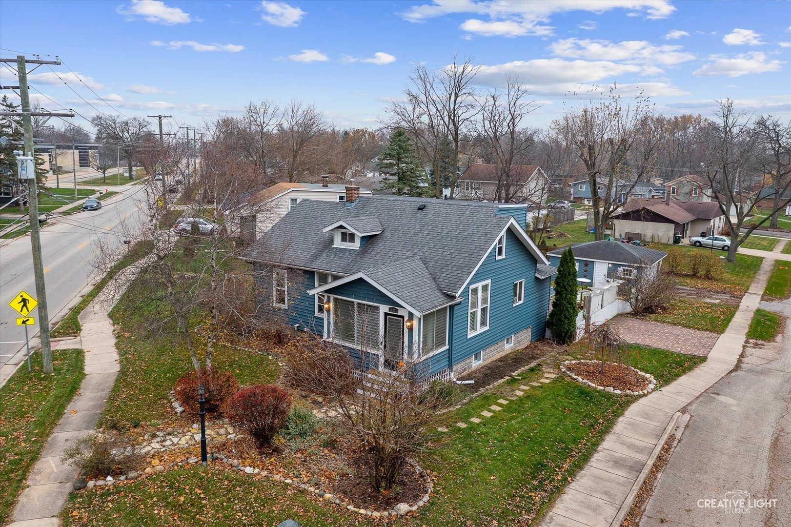 a view of a house with a big yard plants and large trees