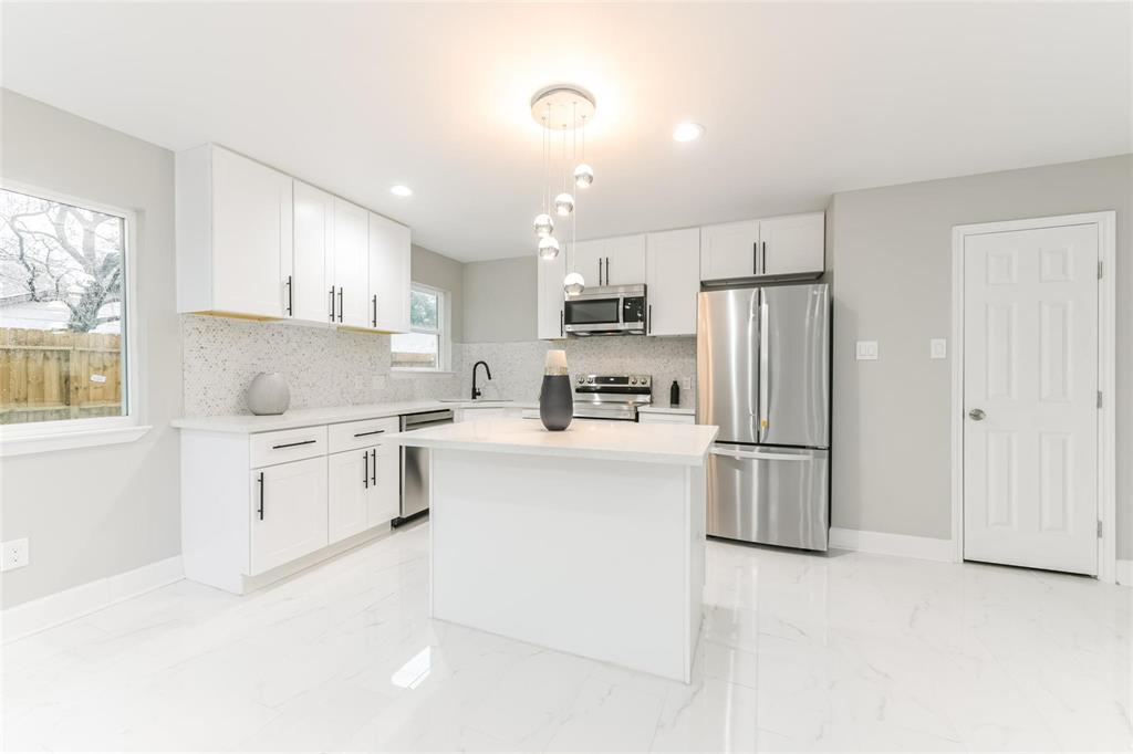 a kitchen with white cabinets and white appliances