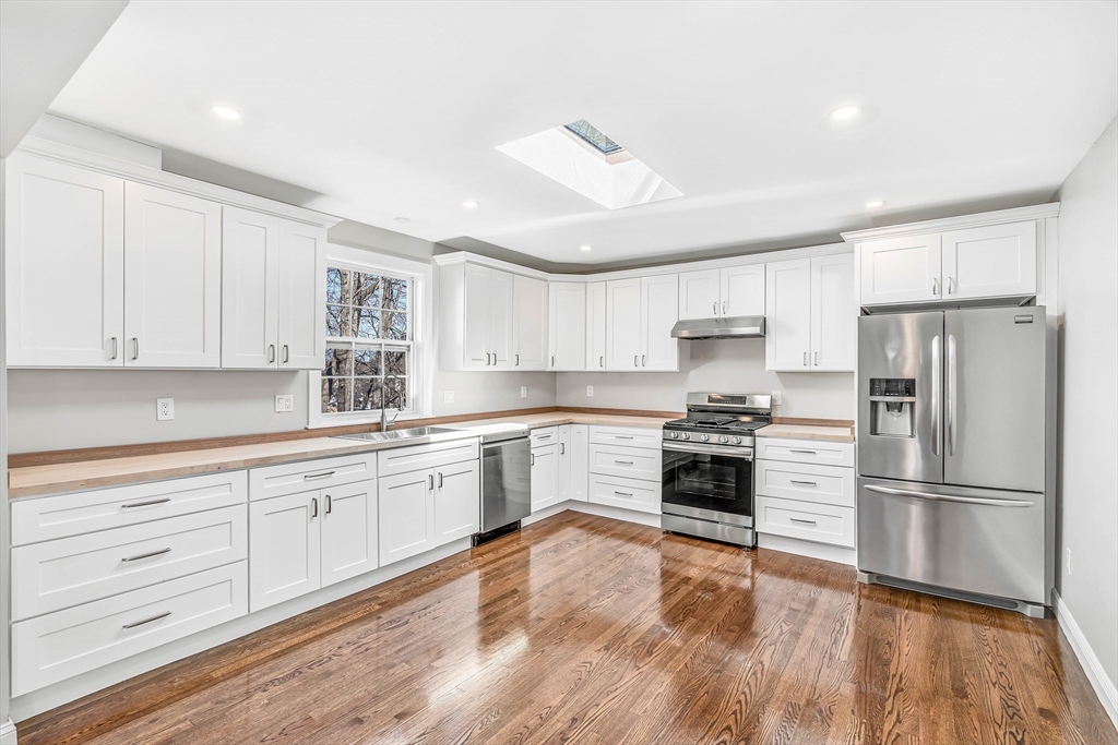 a kitchen with granite countertop white cabinets and stainless steel appliances