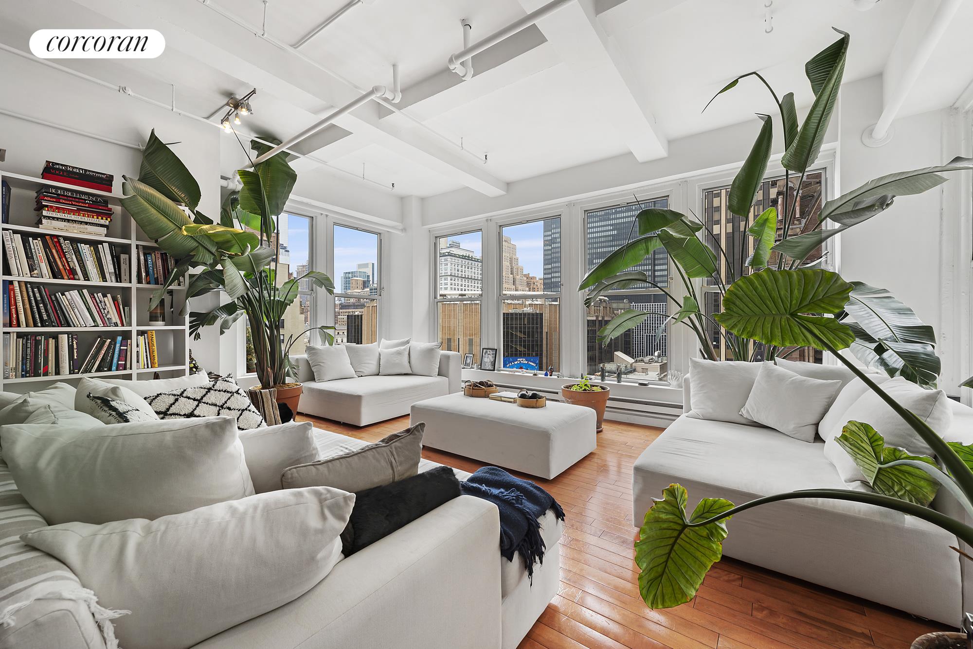 a living room with furniture potted plant and a large window