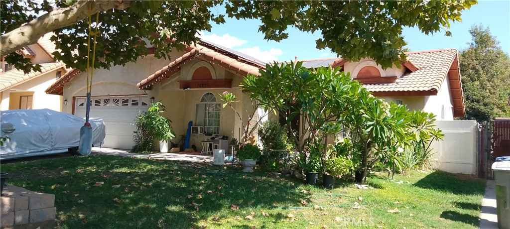 a view of house with a yard and potted plants