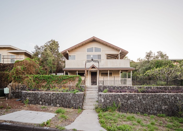 a front view of a house with a garden