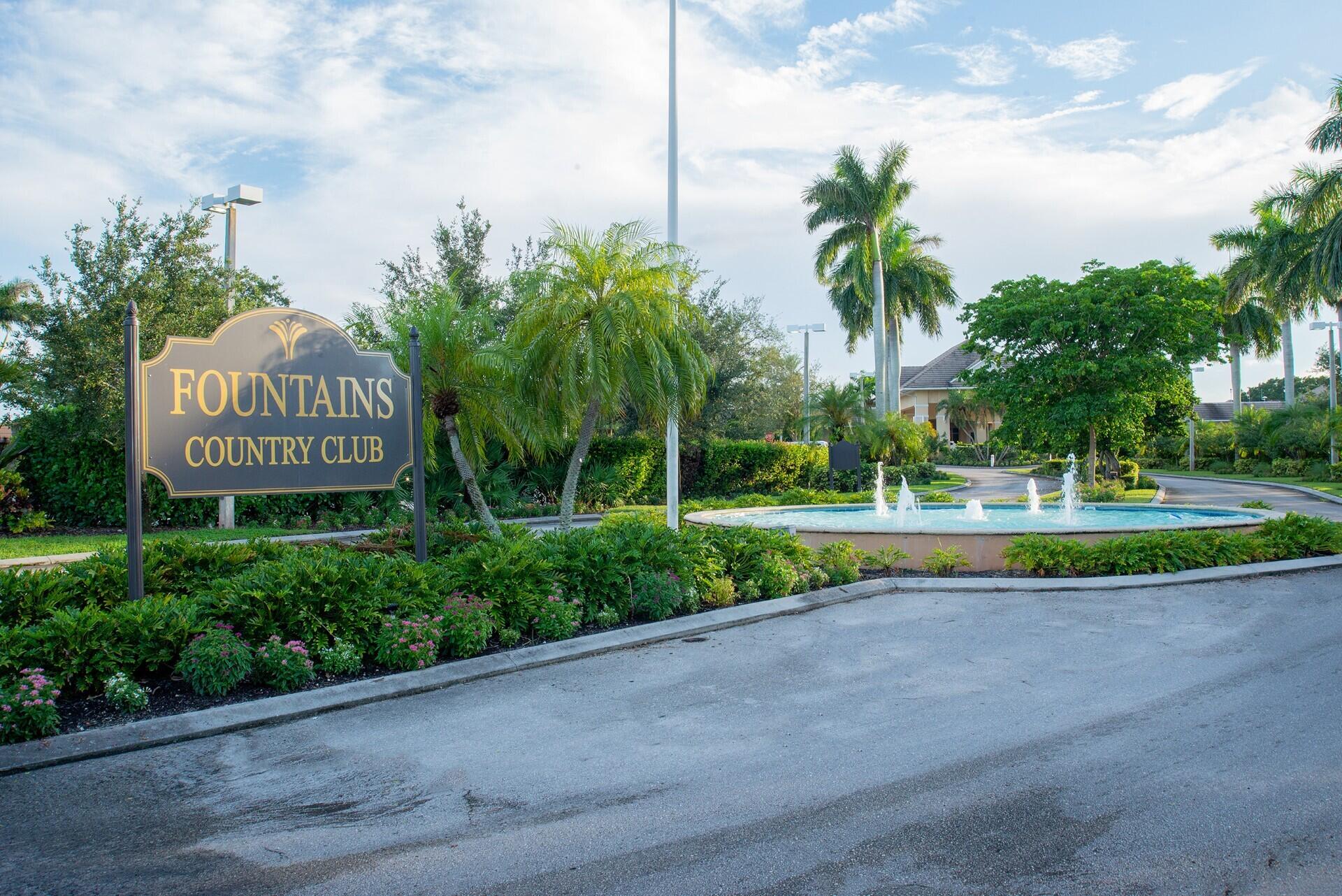 a view of a park that has a street sign and palm trees